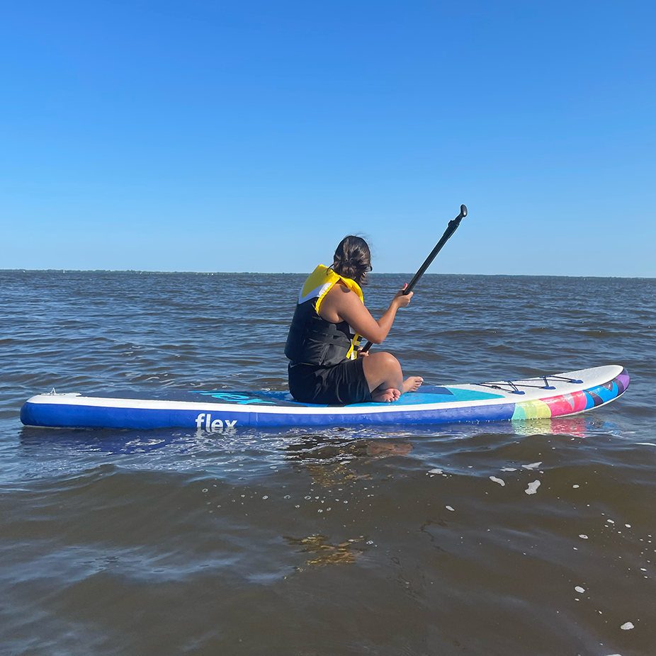 me paddle boarding in a nice lake with a blue sky