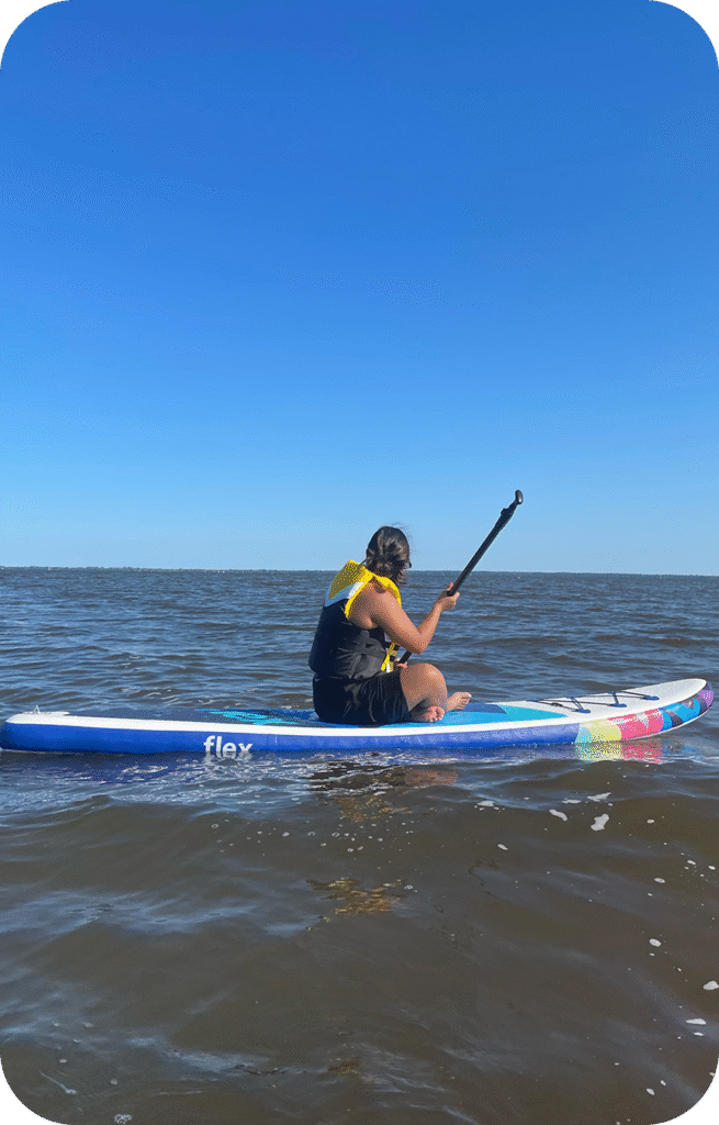 me paddle boarding in a nice lake with a blue sky
